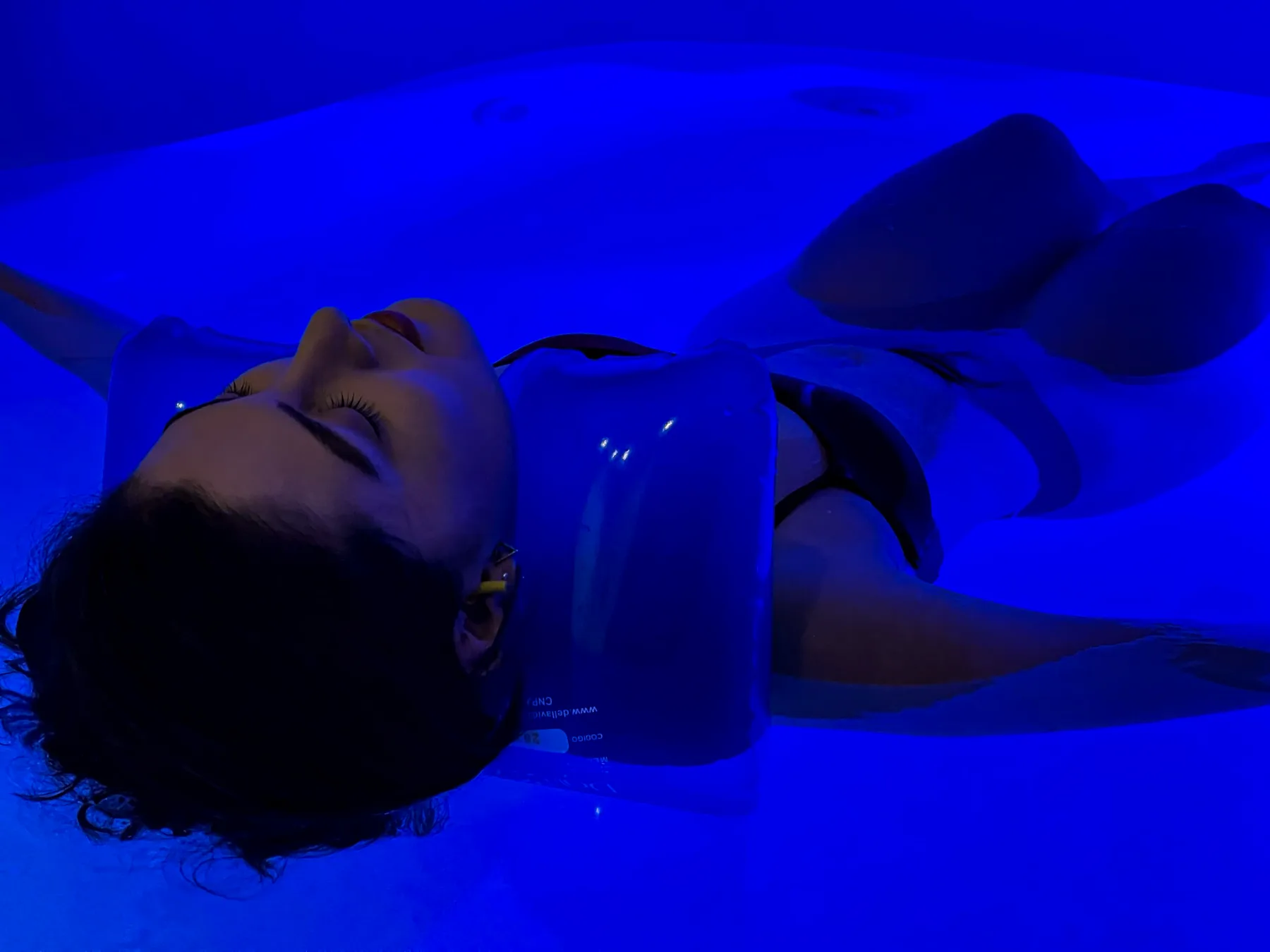 Cliente flutuando na Acqua Pod com luz azul